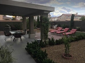 Backyard with seating, BBQ grill and garden.