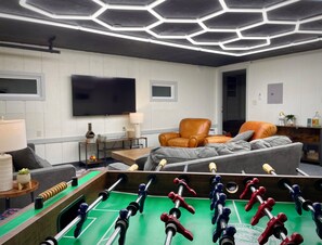 The Waldron Lake Retreat Bonus Game Room: Unwind and have a blast! From foosball and poker nights to cozy movie marathons on the 55" Roku TV with YouTubeTV, we've got all the fun vibes covered—complete with awesome lighting and board games!