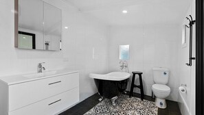 Indulge in luxury in our bathroom with a bathtub, offering a perfect retreat for relaxation. Immerse yourself in a soothing bath, unwind, and rejuvenate in this serene and inviting space.