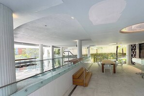 A covered communal terrace features a swimming pool and alfresco dining that can be enjoyed by guests.