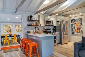 Modern kitchen with sleek quartz countertops, stainless steel appliances, and a breakfast counter, offering a stylish and functional space for cooking and dining | Serhii Vacation Rentals