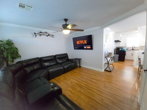 living room with sectional sofa with 3 recliners and a smart TV