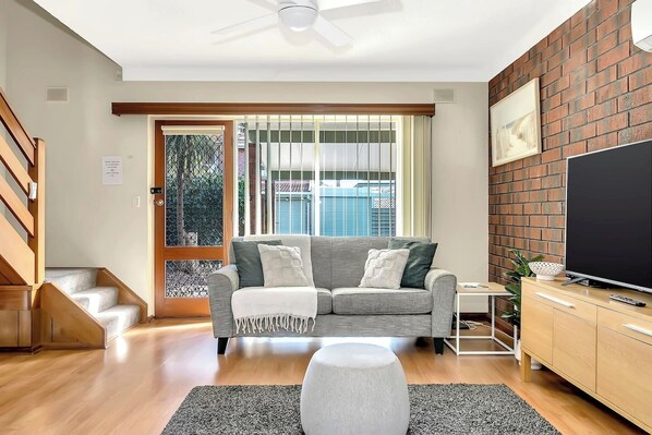 Spread out across two sofas with ottomans in front of the TV in the living room for relaxed days staying in.
