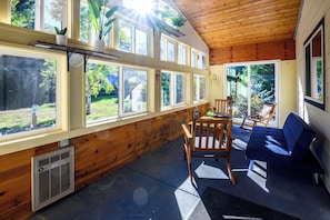 Sunroom is a pleasant space to sit, enjoy a morning coffee, or talk by a built-in heater on a cold day