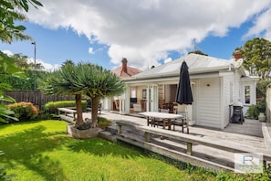 Sunny backyard with deck and lawn