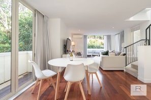 Dining area with doors opening to balcony overlooking the pool