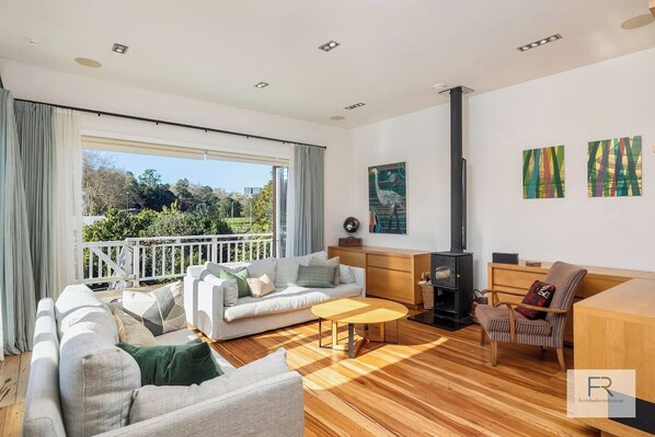 Living Room with bi-fold doors opening to wrap around deck with views over Grey Lynn Park