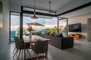 Embrace the serene sunrise from the cozy living room, offering panoramic views of the hills and the shimmering sea.