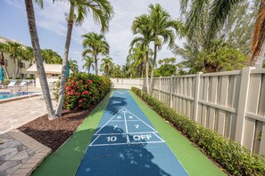 Shuffleboard court in blue/green for relaxing poolside play in fenced area