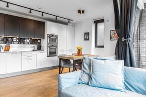 Open-plan living room, Smart-TV and fully equipped kitchen with balcony access