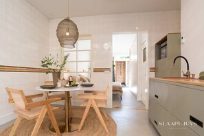 Stylish kitchen and dining area with warm wood details and natural light — perfect for enjoying a slow breakfast or sharing a meal together.