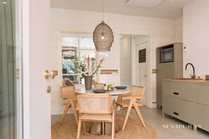 Stylish kitchen and dining area with warm wood details and natural light — perfect for enjoying a slow breakfast or sharing a meal together.