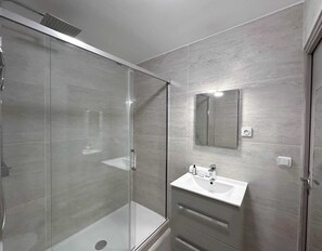 Modern bathroom with shower and toilet.