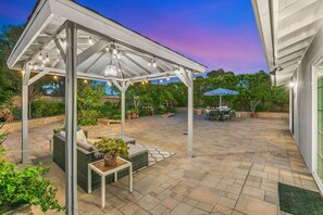 Large backyard with gazebo, outdoor furniture, bbq, table that seats six people