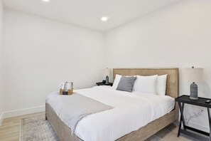 Retreat to this tranquil bedroom for a restful night's sleep. The comfortable king-sized bed is adorned with plush pillows and soft linens, ensuring maximum comfort. Simple yet elegant décor, along with ample natural light, creates a peaceful and inv