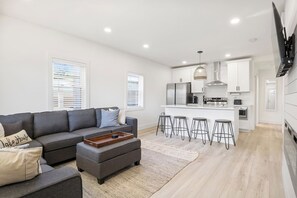 Enjoy ultimate relaxation in this contemporary living room, designed with your comfort in mind. The mounted TV and electric fireplace create a cozy atmosphere for movie nights or quiet evenings. Large windows and modern décor make this the perfect sp