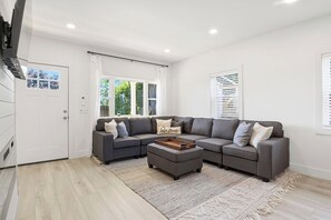 Enjoy ultimate relaxation in this contemporary living room, designed with your comfort in mind. The mounted TV and electric fireplace create a cozy atmosphere for movie nights or quiet evenings. Large windows and modern décor make this the perfect sp