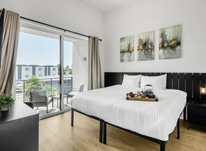 Unit 1 (2nd Floor): Primary Bedroom featuring a King Bed, a Smart TV, a private balcony, and an ensuite primary bathroom.