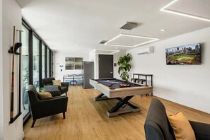 Communal Area: Pool table, lounge areas with smart TVs, communal fridge, and a half bathroom.