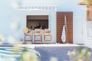 Experience seamless luxury with our pass-thru window, connecting the pool to the kitchen and bar for effortless enjoyment of snacks and drinks all day. Open the striped awning for shade from the afternoon sun. Enjoy the pool views while still prepping in the kitchen!