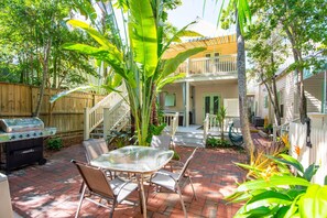 The common area features a dining table and chairs along with a propane BBQ grill, creating a perfect spot for outdoor meals and gatherings.