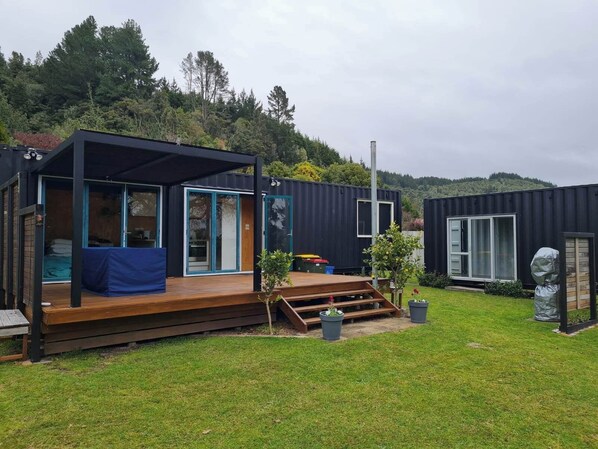 Deck has outdoor table, and louvres with one wind down side. 