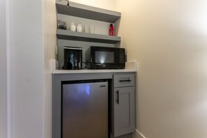 Our well-equipped kitchenette has everything you need to feel at home. With a mini fridge, coffee pot, countertop ice maker, and microwave, you'll have all the essentials for a quick meal or snack. There’s also cupboard space to store your supplies, so yo