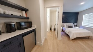 Relax in comfort on this spacious queen-sized bed, surrounded by a beautiful accent wall that adds a touch of charm to the room. Crisp white linens create a serene atmosphere, making it the perfect spot to unwind after a day of exploring the local attract