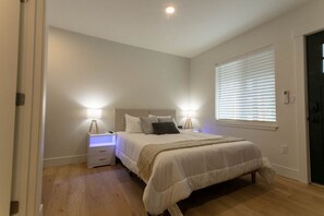 Unwind in comfort on the spacious queen-sized bed, with crisp white linens that create a peaceful ambiance. The side tables are equipped with mood lighting, wireless chargers, and USB ports, adding convenience and relaxation to your stay.