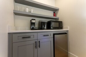 Our fully stocked kitchenette is designed to make you feel right at home. Featuring a mini fridge, coffee maker, countertop ice maker, and microwave, you'll have everything you need to prepare a quick meal or snack. Plus, ample cupboard space is available
