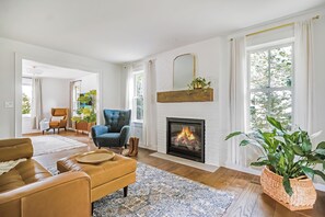 Relax in this bright, airy living room anchored by a charming fireplace. 