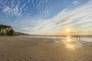 Stroll across the soft sand of Porthtowan at sun set