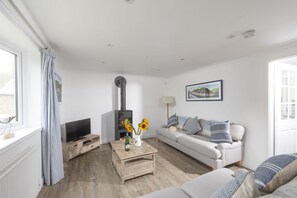 Castaways, Porthtowan. Ground Floor: The lovely sitting room offers two comfy sofas, a Smart Television and a characterful wood burning stove