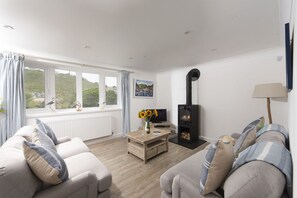Castaways, Porthtowan. Ground Floor: The sitting room is light and spacious, yet made cosy by the warmth of the wood burning stove