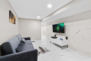 Modern entertainment space with a plush sofa and gaming console, ideal for relaxation and fun.
