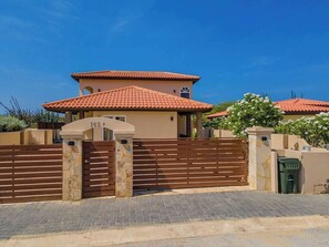 Step into luxury as you approach the front of this stunning villa, set in an upscale neighborhood. The modern design and lush surroundings create the perfect first impression of your tropical getaway.
