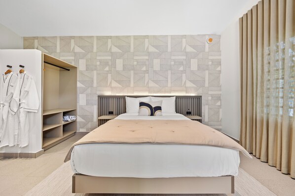 Bright and airy bedroom with a king-sized bed, a desk, and a closet.