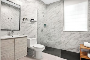 This functional bathroom includes a toilet, sink, and shower.