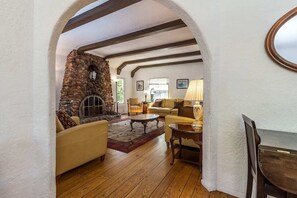 Step into the inviting living room, featuring comfortable couches, a grand fireplace, and a TV—perfect for family gatherings, entertainment, and relaxation.