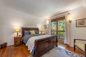 This bright and airy upstairs bedroom features a comfortable queen bed and a private balcony with a view of the pool—perfect for a restful retreat.