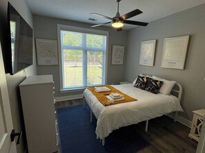 Charming Bedroom: Bright space with stylish decor, a plush bed, and vibrant garden views!