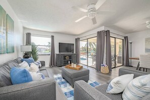 Living room features 55 inch smart tv and views of the pool