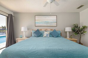 Primary bedroom with king bed, walk-in closet, and direct access to the pool.