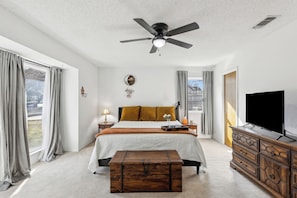 Master bedroom with dresser, walk-in closet, nightstands, and ensuite bathroom.