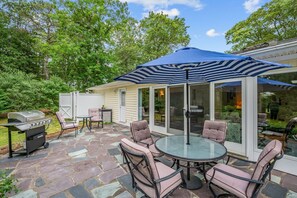 Dine al fresco on the patio with easy access through the sliding doors to the dining room and kitchen beyond - 38 Monomoyic Way Chatham Cape Cod-Poppy's Place-NEVR