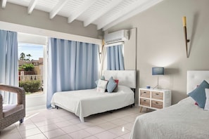 Cozy and bright bedroom with comfortable beds, air conditioning, and a beautiful view. Perfect for a relaxing stay!