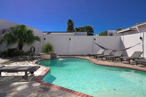 Relax in our private oasis with a sparkling pool, comfy lounge chairs, and a hammock. Perfect for a sunny getaway!