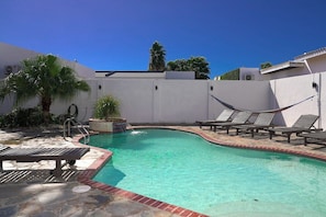 Relax in our private oasis with a sparkling pool, comfy lounge chairs, and a hammock. Perfect for a sunny getaway!