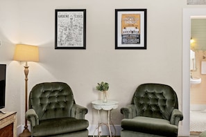 Unwind in this inviting suite featuring plush chairs and lamp, perfect for reading or lounging.
