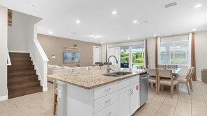 Spacious open-concept living area with modern kitchen and patio access, perfect for relaxing and entertaining.